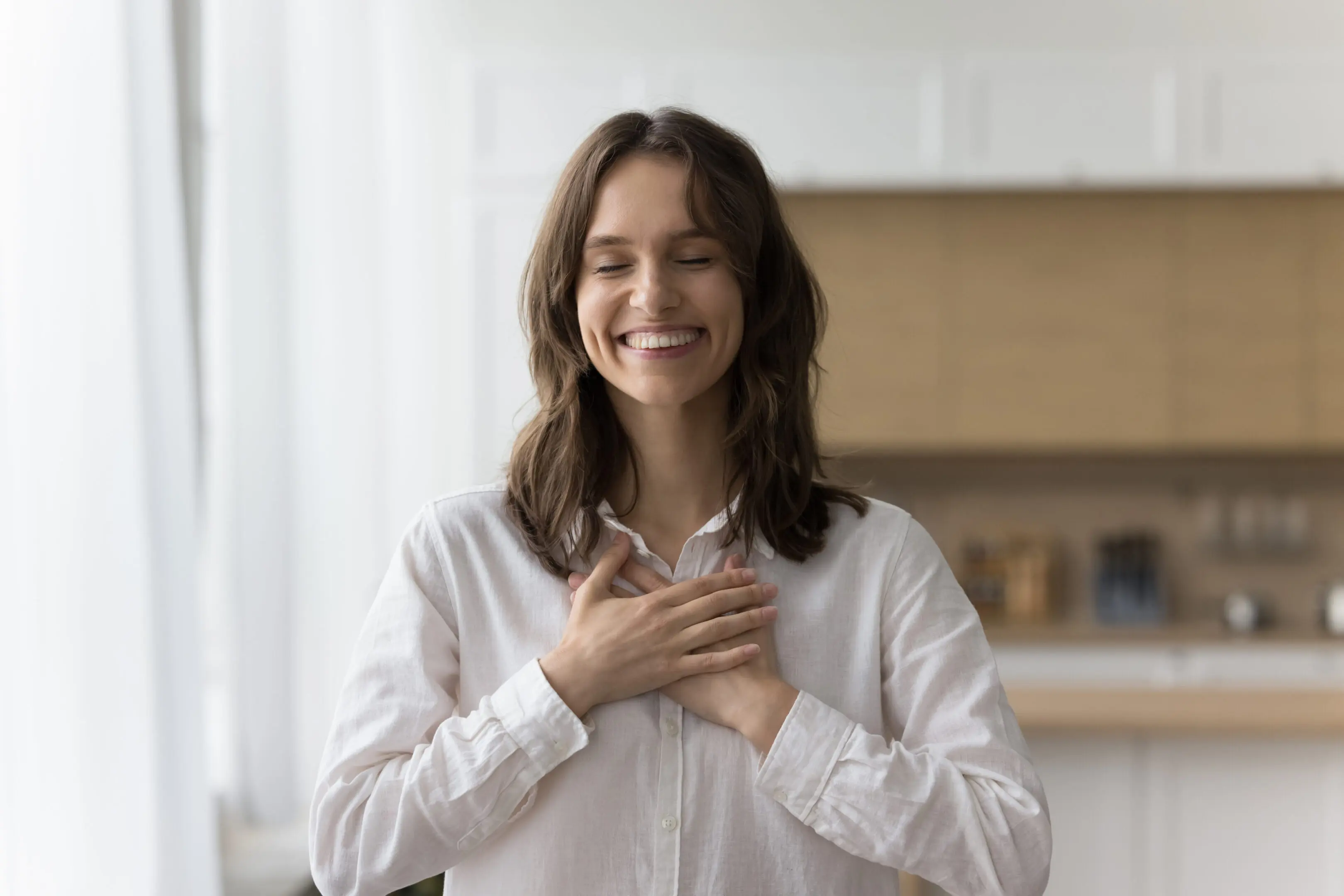 Happy peaceful pretty woman making gesture of gratitude, thank, pride, kindness, stacking hands on chest with toothy smile and closed eyes, enjoying peace, positive, thankful emotions
